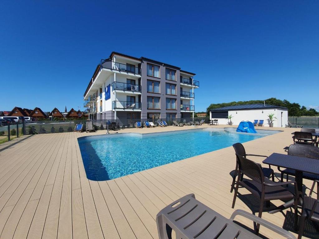 un hôtel avec une piscine et un bâtiment dans l'établissement Prywatne apartamenty w hotelu - 365PAM, à Sarbinowo