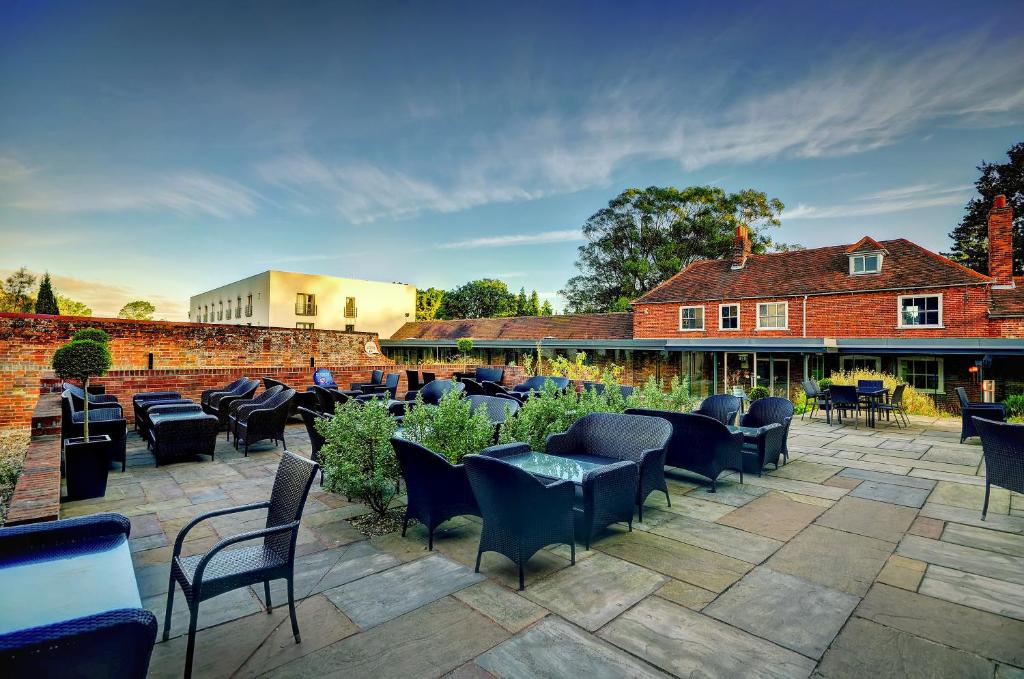 a patio with chairs and tables and a building at Lifehouse Spa And Hotel in Frinton-on-Sea