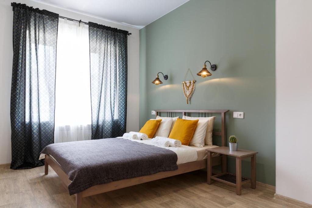 Un dormitorio con una cama con almohadas amarillas y una ventana en Botanika Hostel, en Kazán
