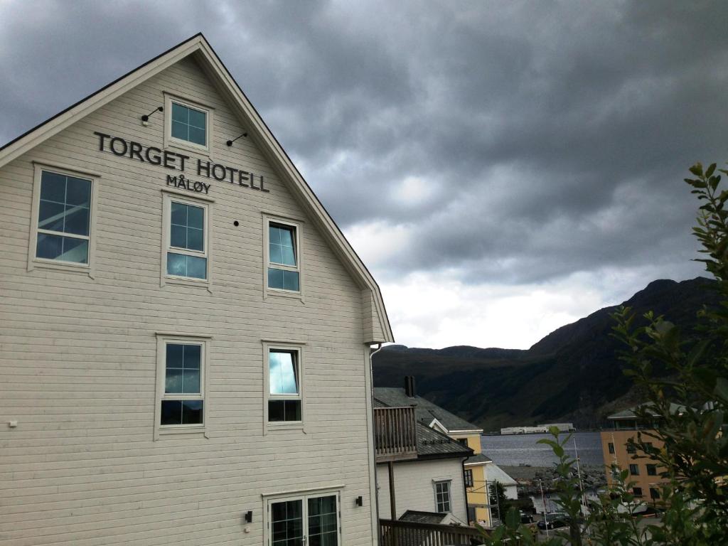 a white building with a forest hotel sign on it at Torget Hotell in Måløy