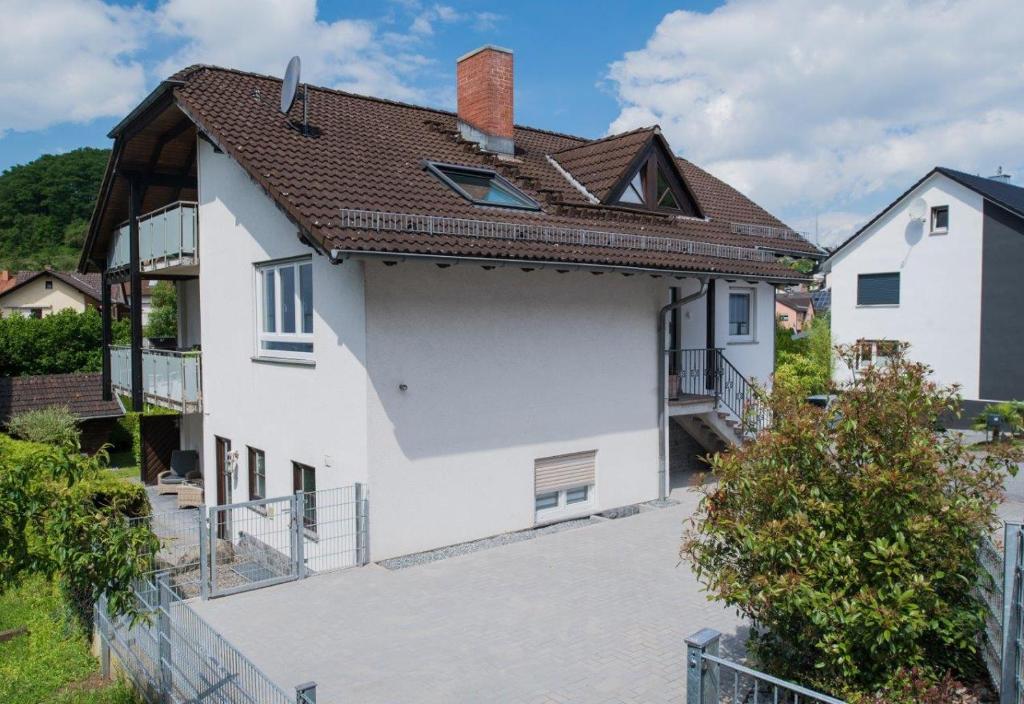 ein weißes Haus mit braunem Dach in der Unterkunft Ferienwohnungen Mildenberger in Birkenau