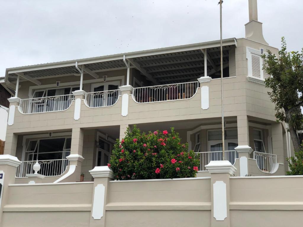 a building with a balcony with a flower bush at Authentic Mossel Bay in Mossel Bay