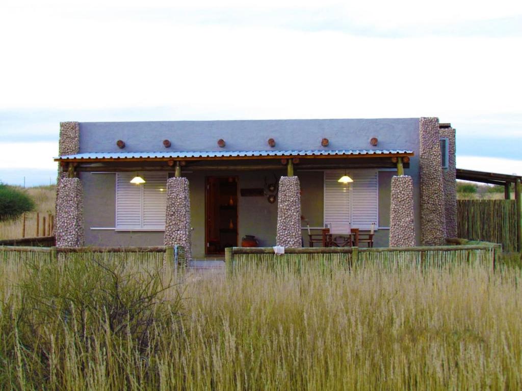 une maison au milieu d'un champ d'herbe haute dans l'établissement Kalahari Cottage, à Askham