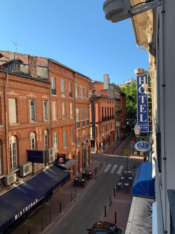 Blick auf eine Straße mit Tischen und Gebäuden in der Unterkunft Hotel Wilson Square in Toulouse