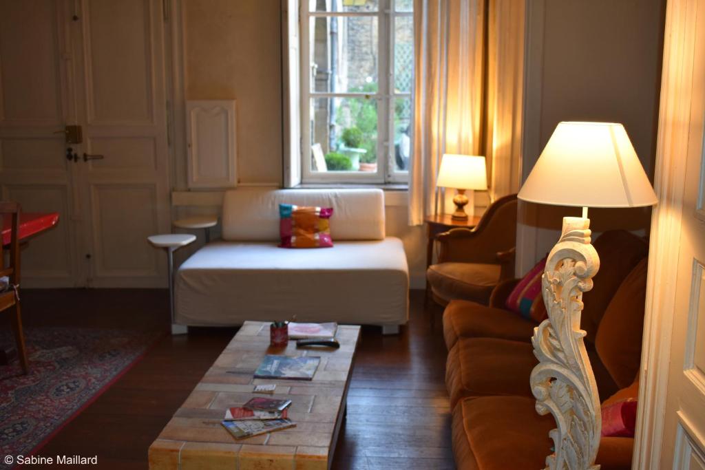 a living room with a couch and a table at Hôtel particulier Maleteste in Dijon