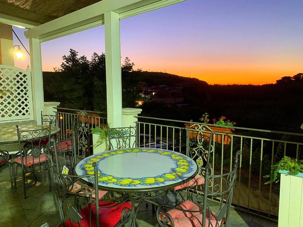 a balcony with a table and chairs and a sunset at Hotel Isolabella in Ventotene