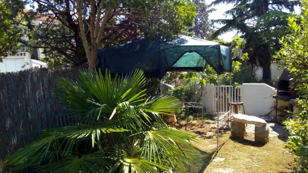 a backyard with a tent hanging over a fence at Apartments Kavan in Barbariga