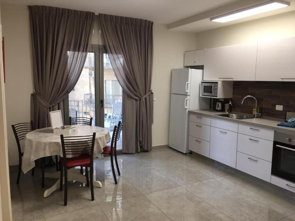 a kitchen with a table and chairs and a kitchen with a table and a kitchen at Segal in Jerusalem Apartments in Jerusalem