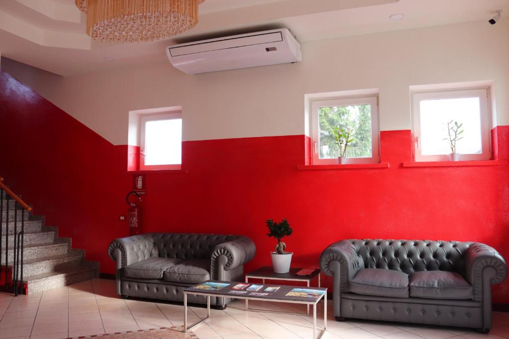 2 Sofas in einem Raum mit roten Wänden in der Unterkunft Hotel italia dormelletto in Dormelletto