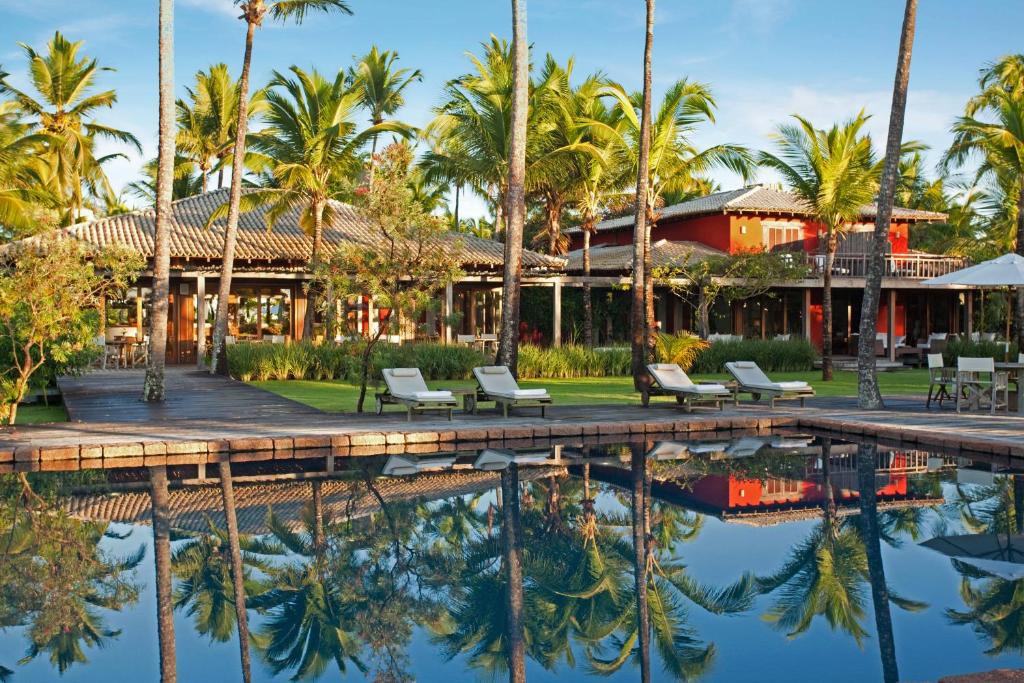 a resort with palm trees and a pool at Fazenda São Francisco do Corumbau in Corumbau