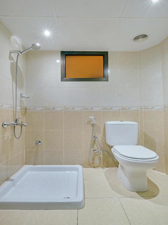 a bathroom with a toilet and a bath tub at Al Rayan Hotel in Ajman 