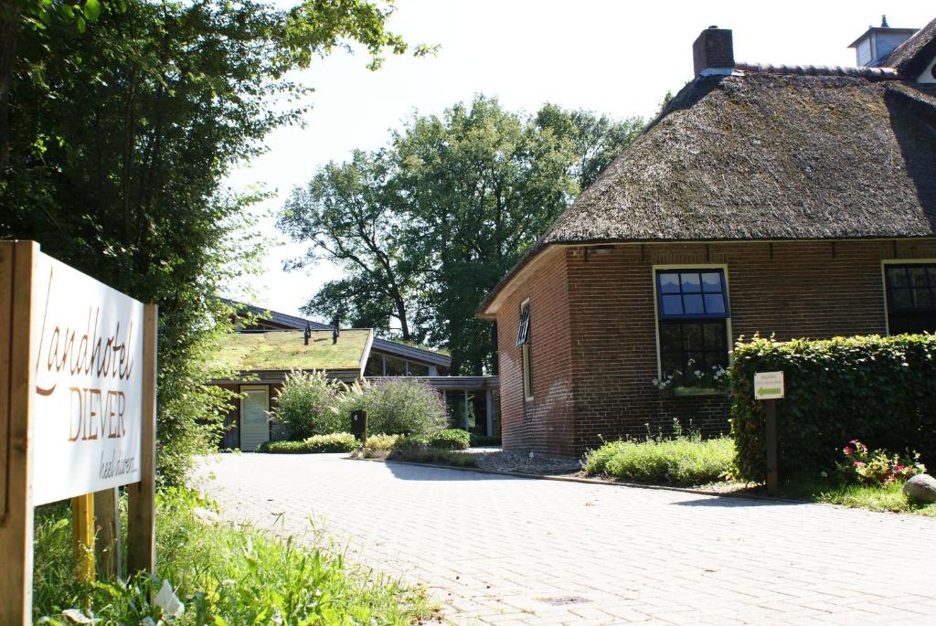 un bâtiment en briques avec un panneau devant lui dans l'établissement Landhotel Diever, à Diever