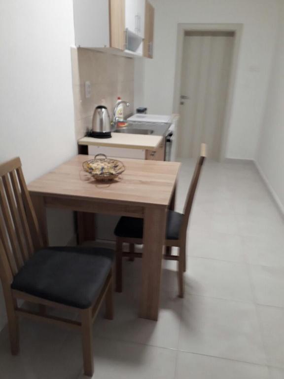 a small kitchen with a wooden table and chairs at Apartments Dionis in Kotor