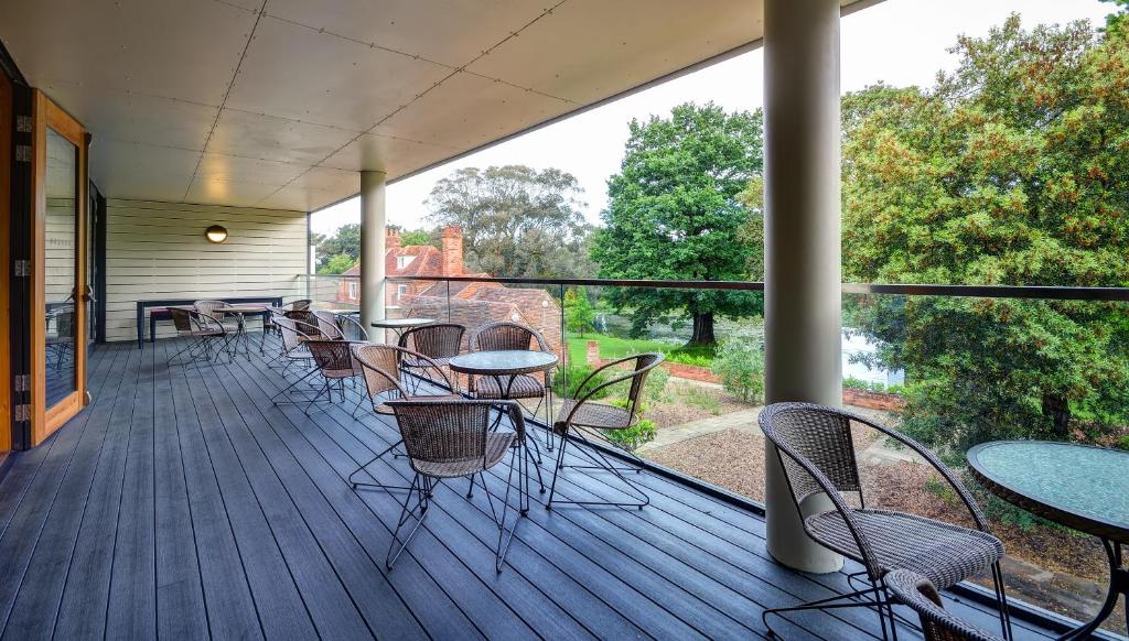 a porch with tables and chairs on a deck at Lifehouse Spa And Hotel in Frinton-on-Sea