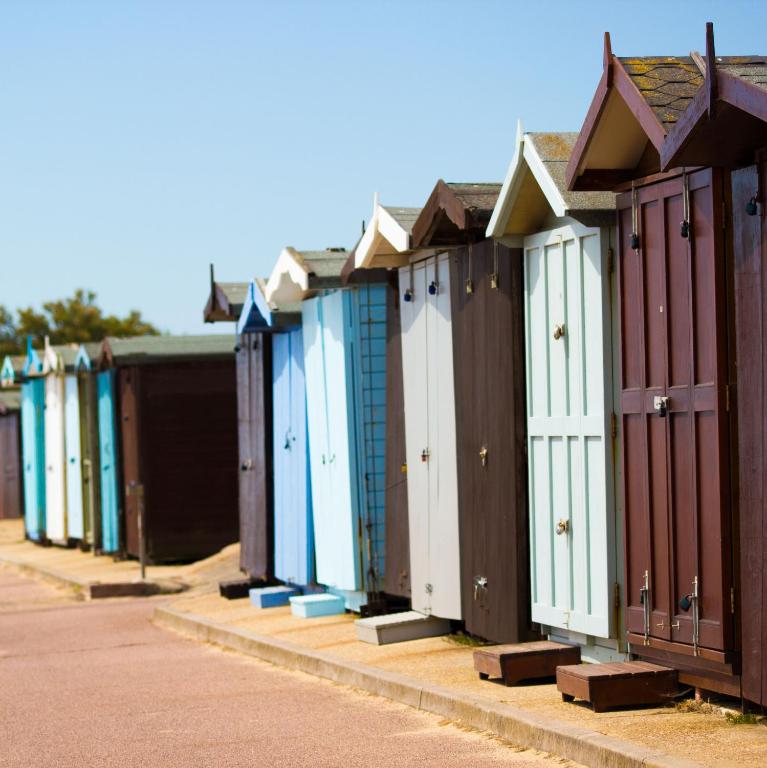 a row of beach huts are lined up in a row at Lifehouse Spa And Hotel in Frinton-on-Sea