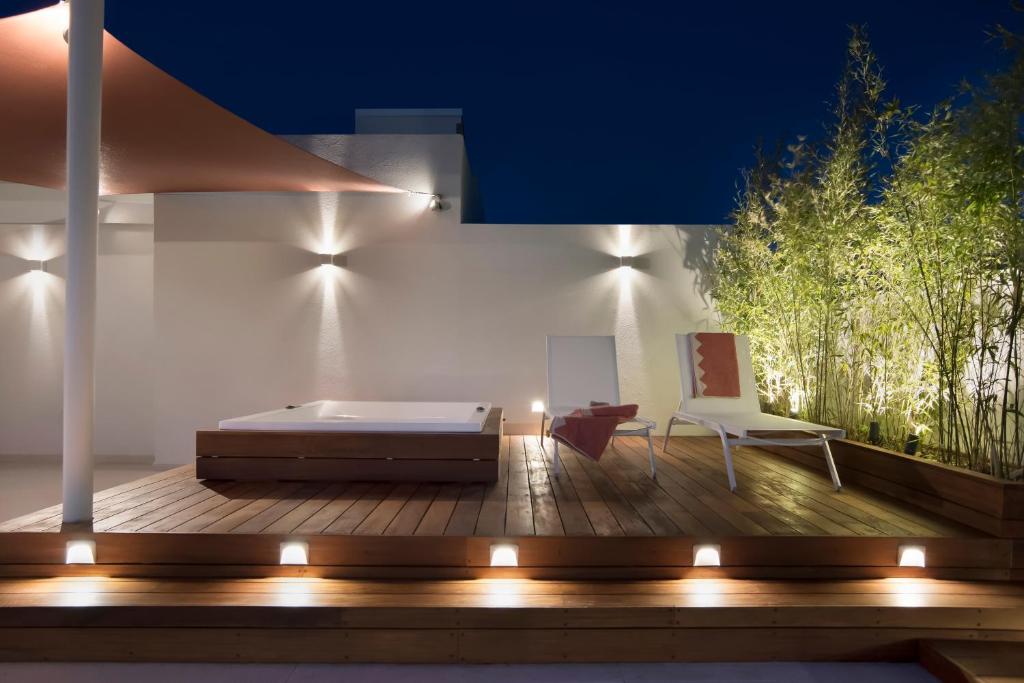 a bedroom with a bed and two chairs on a deck at Glyfada South42 in Athens