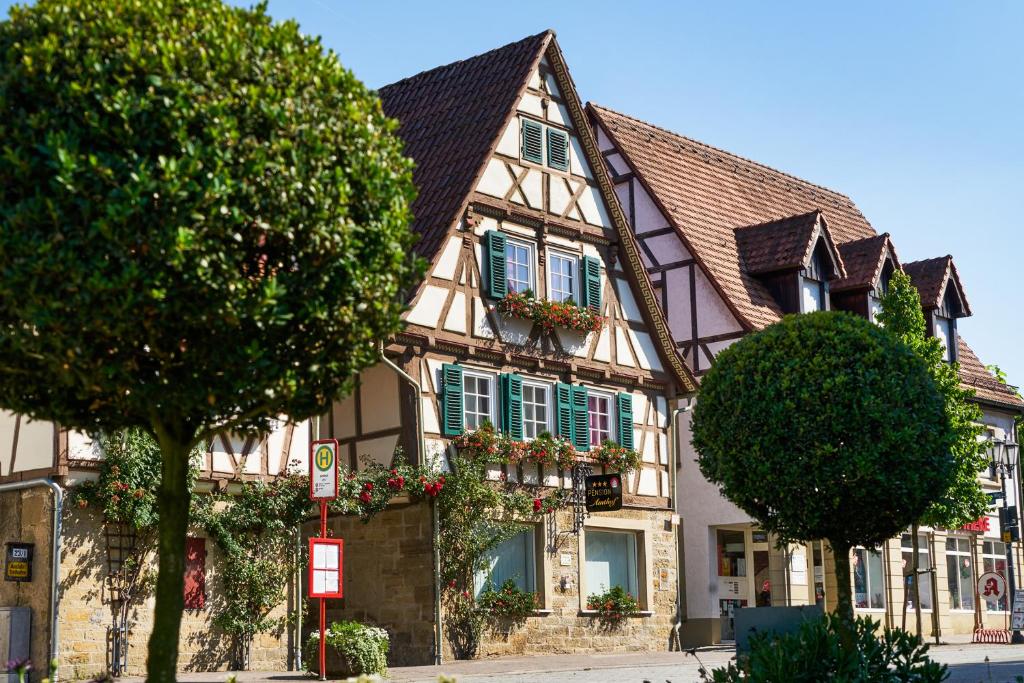 un edificio con persianas verdes y flores en las ventanas en Pension Amthof en Oberderdingen