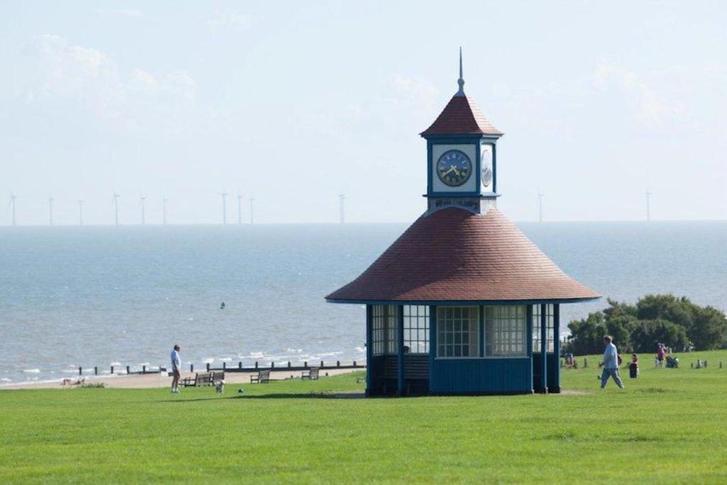 a gazebo with a clock tower on the beach at Lifehouse Spa And Hotel in Frinton-on-Sea