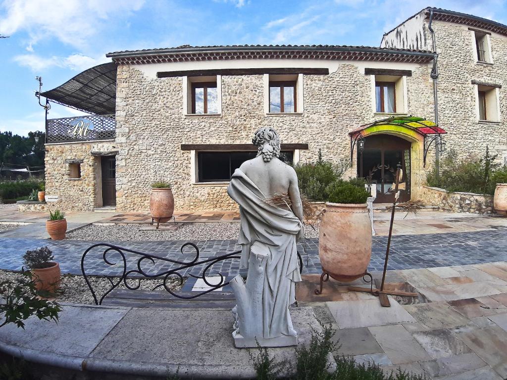 a statue of a woman standing in front of a building at Bastide De Mazan in Riez