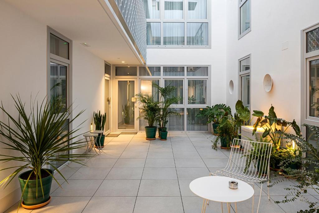 wewnętrzny dziedziniec z doniczkami w budynku w obiekcie Apartamentos y estudios céntricos Conil Home Suite w mieście Conil de la Frontera