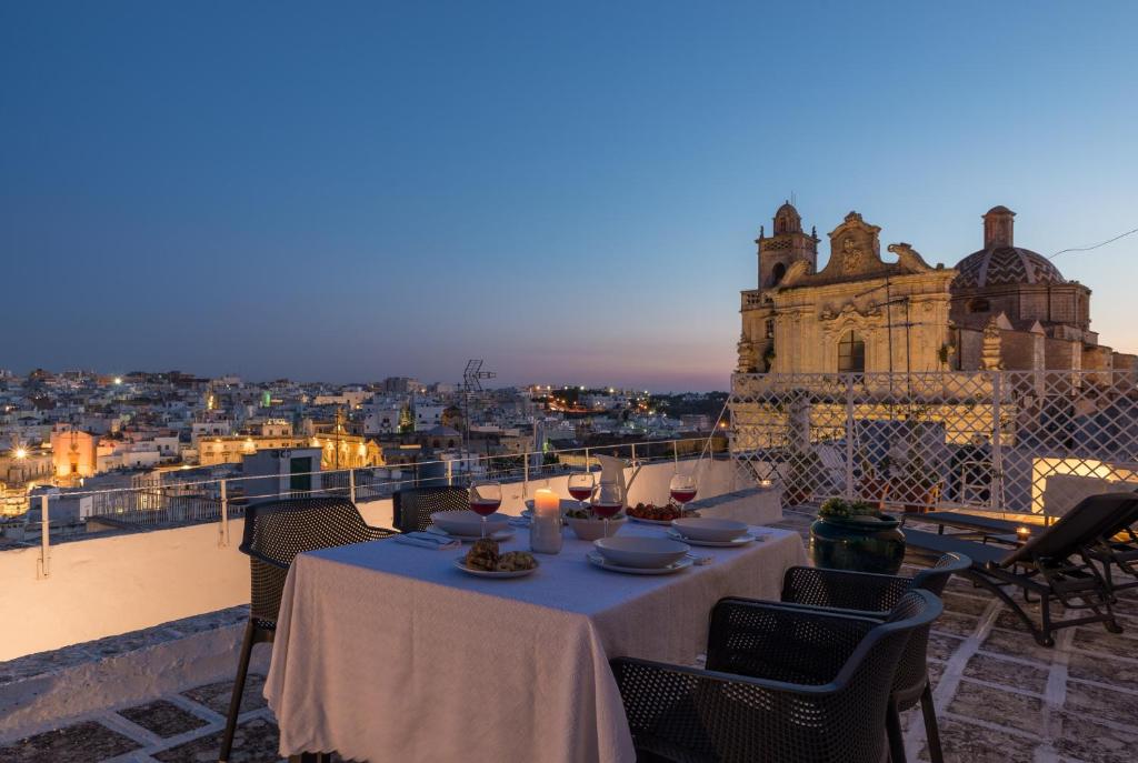 a table on a balcony with a view of a city at Palazzo Le Cupole by Wonderful Italy in Ostuni
