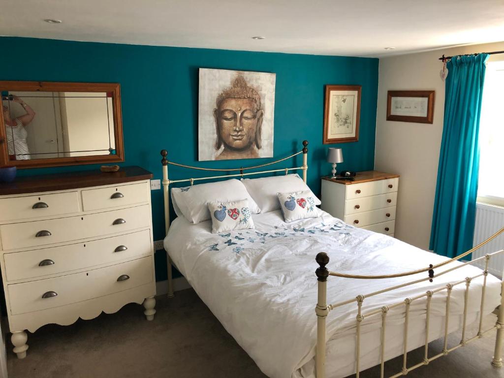 um quarto com uma cama com uma cómoda e um espelho em Buckfield Roost 3 bedroom Newlyn, free parking for 2 cars em Newlyn