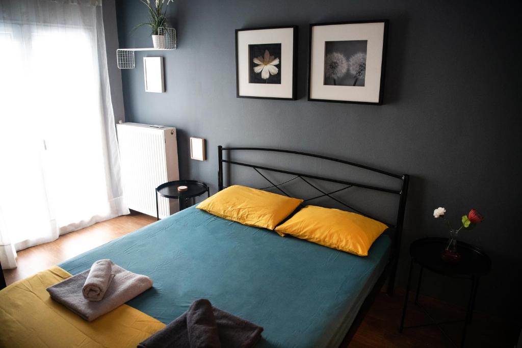 - une chambre dotée d'un lit avec des draps jaunes et bleus dans l'établissement Grey & Cozy Luxury Apartment, à Thessalonique