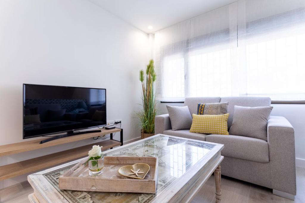 sala de estar con sofá y TV en Livemalaga Balneario Beach, en Málaga