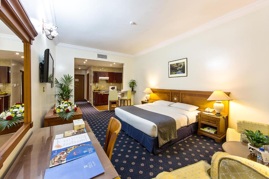 um quarto de hotel com uma cama e uma sala de estar em Rolla Residence Hotel Apartment em Dubai