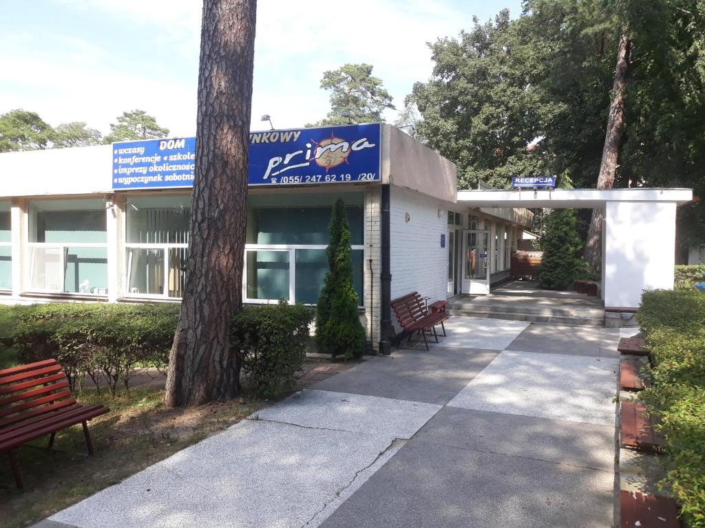 a building with two benches in front of it at Prima in Krynica Morska