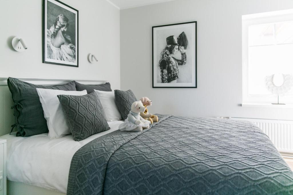a teddy bear sitting on a bed in a bedroom at Viigi Villa in Haapsalu