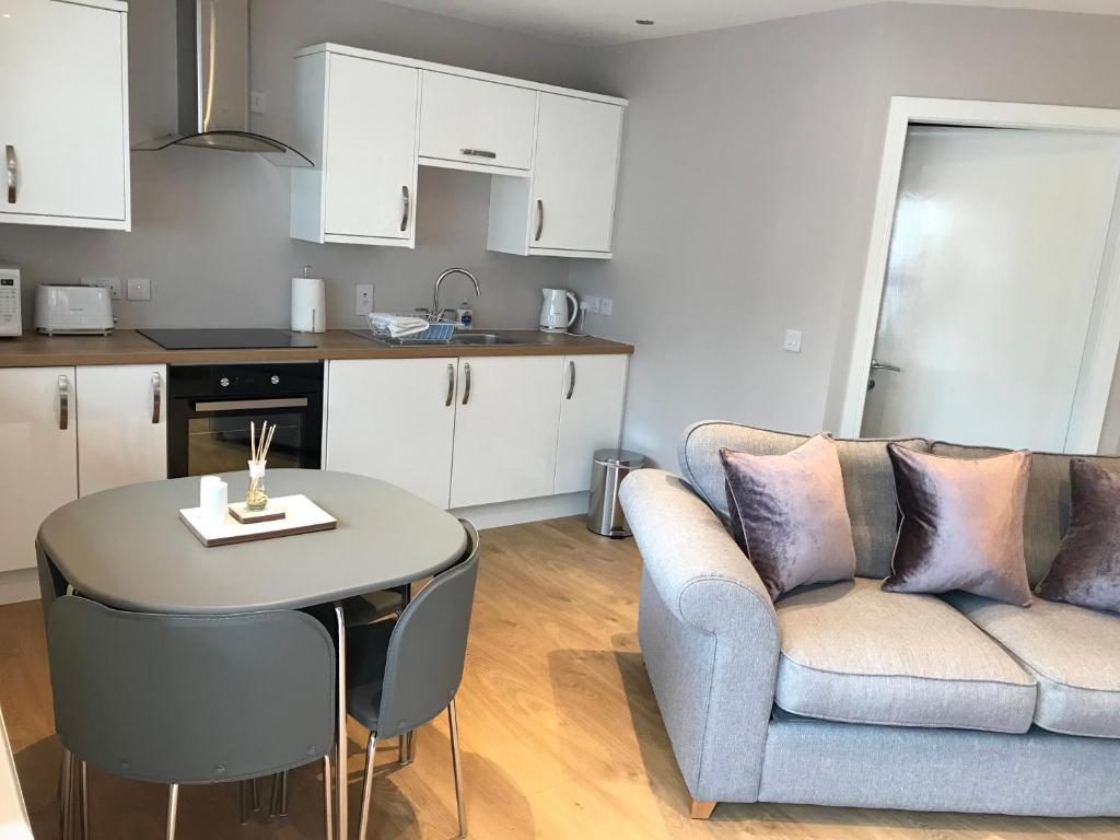 a kitchen and a living room with a couch and a table at River cottage in Fort William