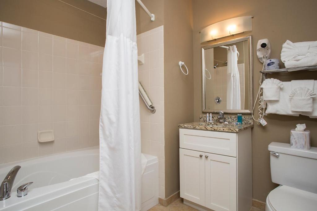 a bathroom with a tub and a toilet and a sink at Avista Resort in Myrtle Beach