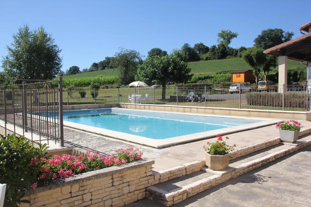 una piscina en un patio con flores en Monlezun en Monlezun