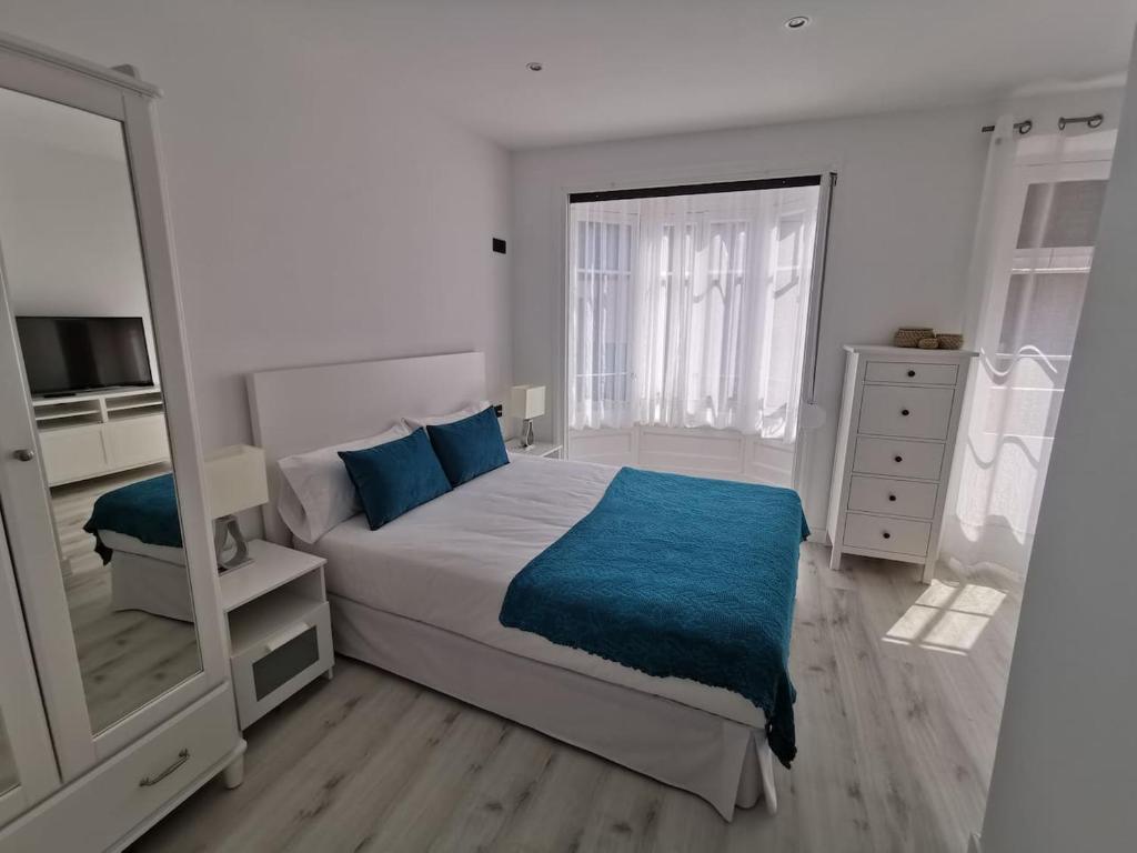 um quarto com uma cama grande e um espelho em Begoña 18 Rest & Adventure em Gijón