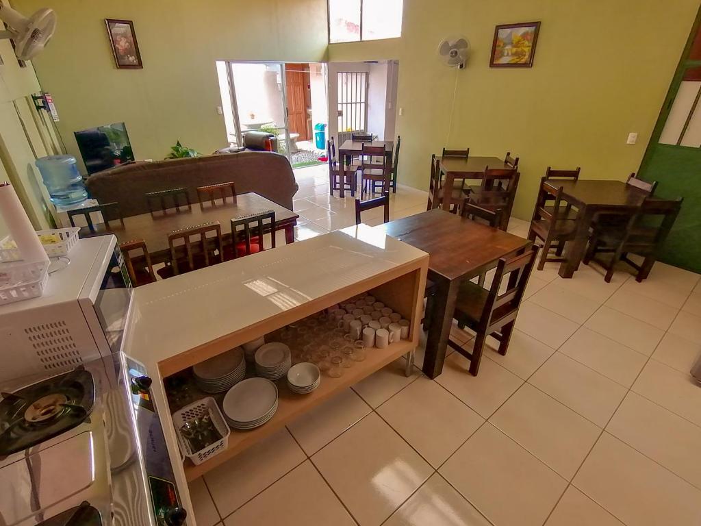 a kitchen and dining room with tables and chairs at Nice Place Hostel in Fortuna