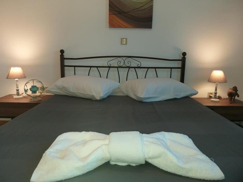 a bed with a pair of white towels on it at Nikolettas Apartments in Faros