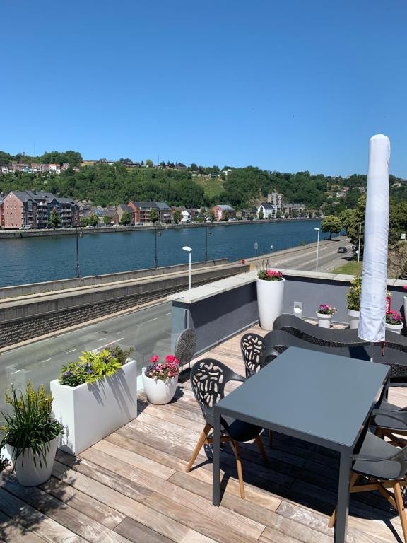 d'une terrasse sur le toit avec une table et des chaises. dans l'établissement Meuse View, à Huy