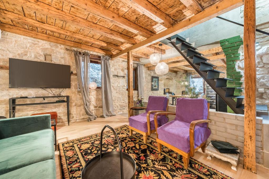 a living room with purple chairs and a staircase at Livo Disno 12 in Split