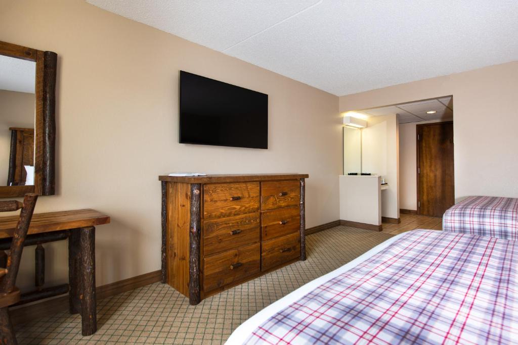 a bedroom with a bed and a television on the wall at Lodge of the Ozarks in Branson