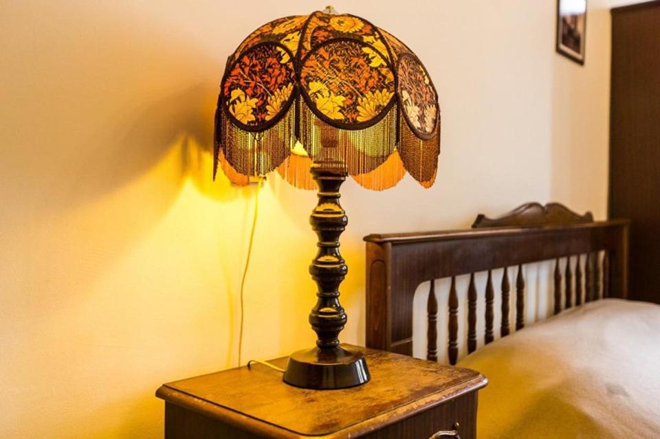 una lámpara sobre una mesa junto a una cama en Apartments in the Customs Square, en Leópolis