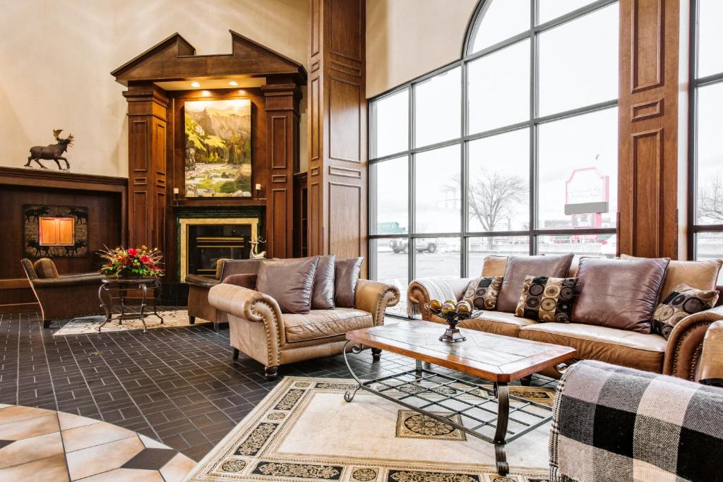 a living room with couches and a table and a fireplace at Lodge of the Ozarks in Branson
