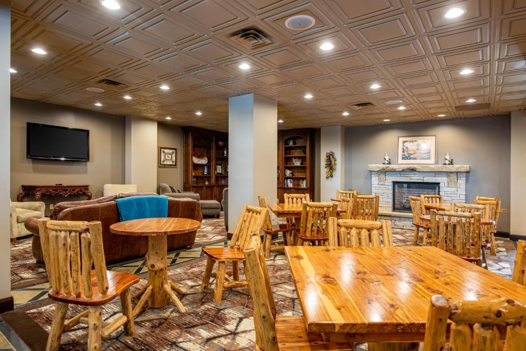a room with tables and chairs and a fireplace at Lodge of the Ozarks in Branson