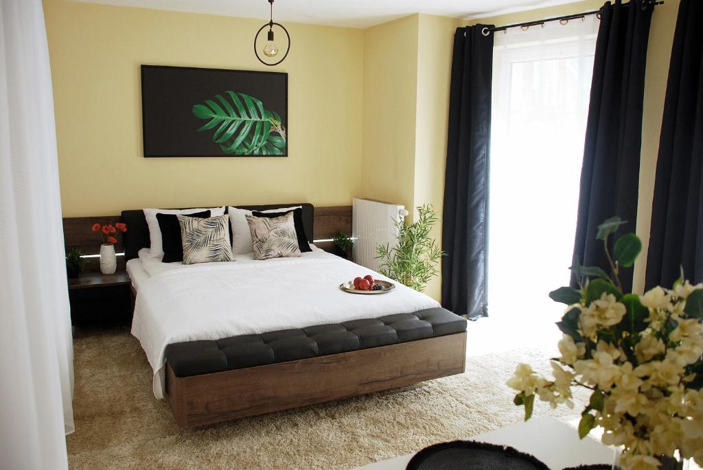 um quarto com uma cama grande com lençóis brancos e almofadas em Central Point em Zielona Góra