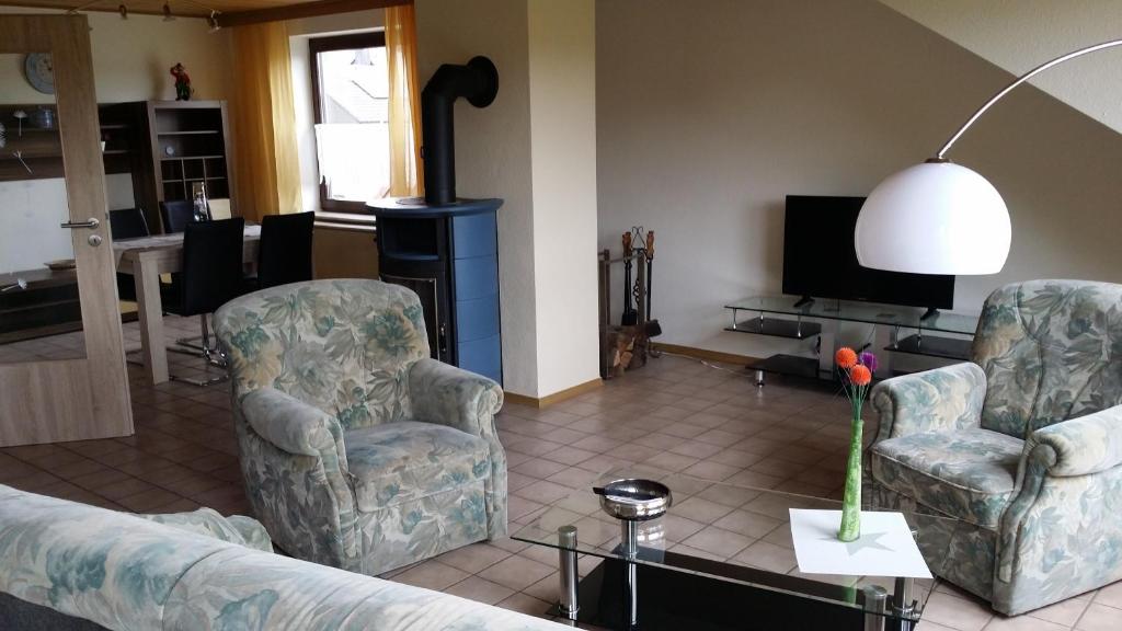 a living room with two chairs and a fireplace at Ferienwohnung Am Frankenbach in Franken