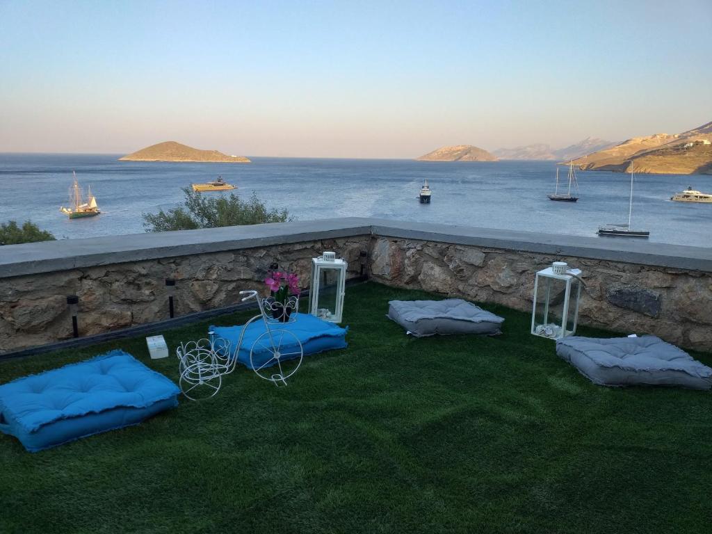 a patio with a table and chairs on the grass at Aegean Blue in Panteli