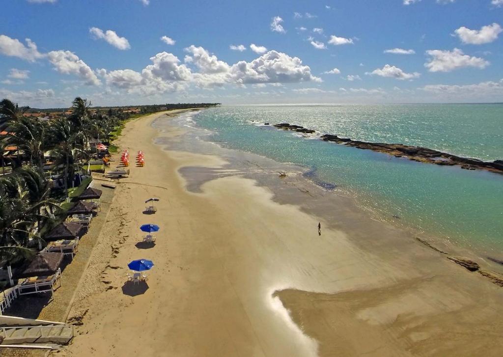 una vista aérea de una playa con sombrillas y el océano en Apart Marinas Tamandaré en Tamandaré