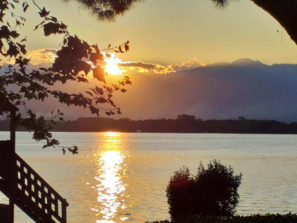a sunset over the water with mountains in the background at Alla Ghigliotta in Viverone