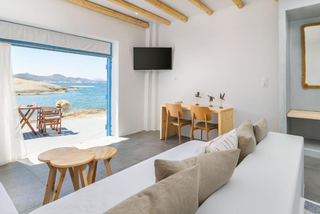 ein Wohnzimmer mit einem Sofa und Meerblick in der Unterkunft Beach Suite Syrma in Pachaina