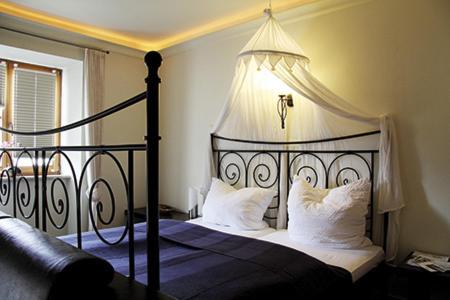 a bedroom with a black and white bed with white pillows at Schlosshof anno 1743 in Wolnzach